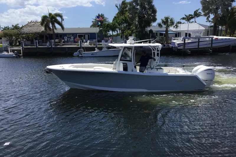 Slide: The Image of 2024 Sea Hunt Gamefish 28 Coffin Box boat cruising on a sunny waterway. - 10