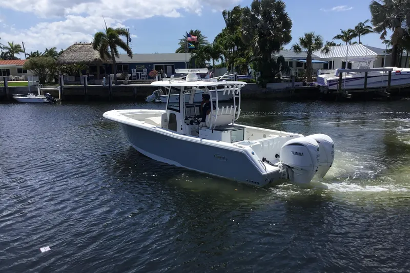 Slide: The Image of 2024 Sea Hunt Gamefish 28 Coffin Box boat cruising on a sunny waterway. - 11
