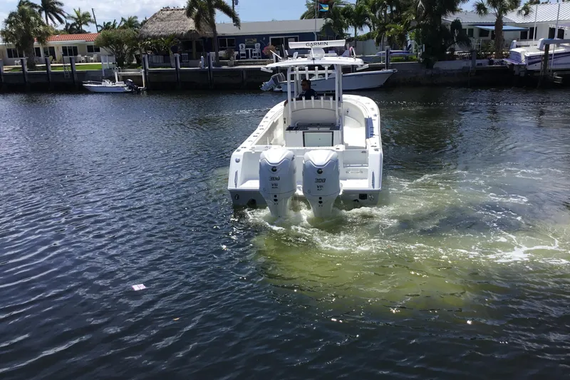 Slide: The Image of 2024 Sea Hunt Gamefish 28 Coffin Box boat cruising on a sunny waterfront. - 13