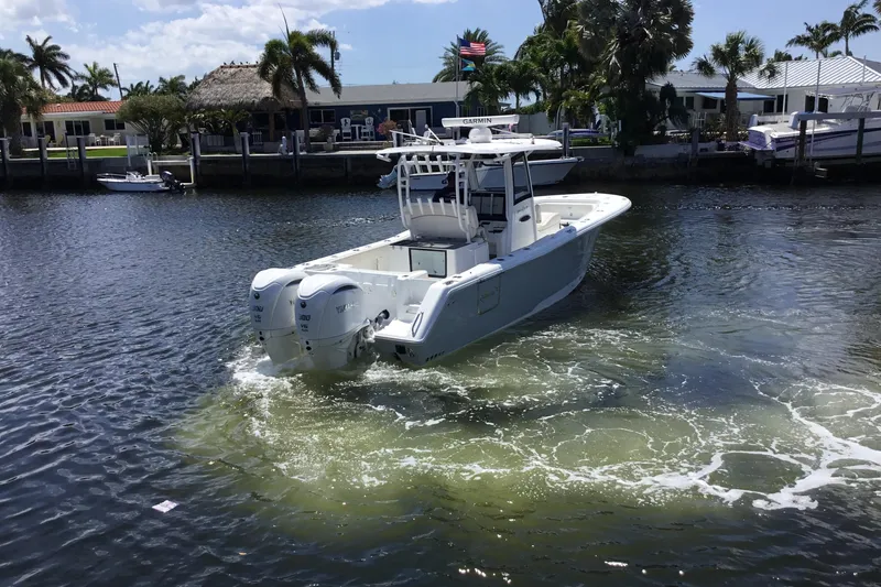 Slide: The Image of 2024 Sea Hunt Gamefish 28 Coffin Box boat cruising in a scenic waterfront setting. - 14