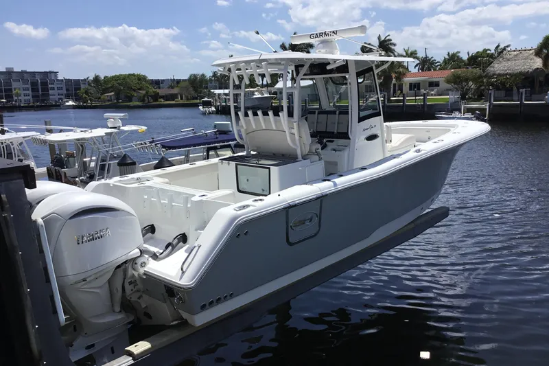 The Image of 2024 Sea Hunt Gamefish 28 Coffin Box boat docked by waterfront homes. - 2