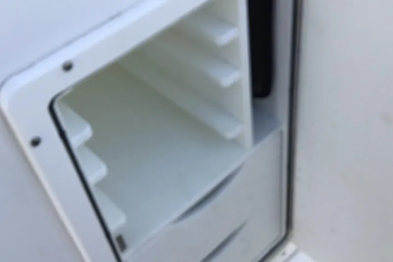 Slide: The Image of 2024 Sea Hunt Gamefish 28 Coffin Box interior storage compartment, white and spacious design. - 34