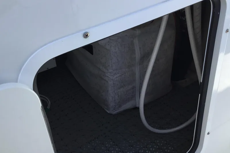 Slide: The Image of 2024 Sea Hunt Gamefish 28 Coffin Box storage compartment with visible hoses. - 35