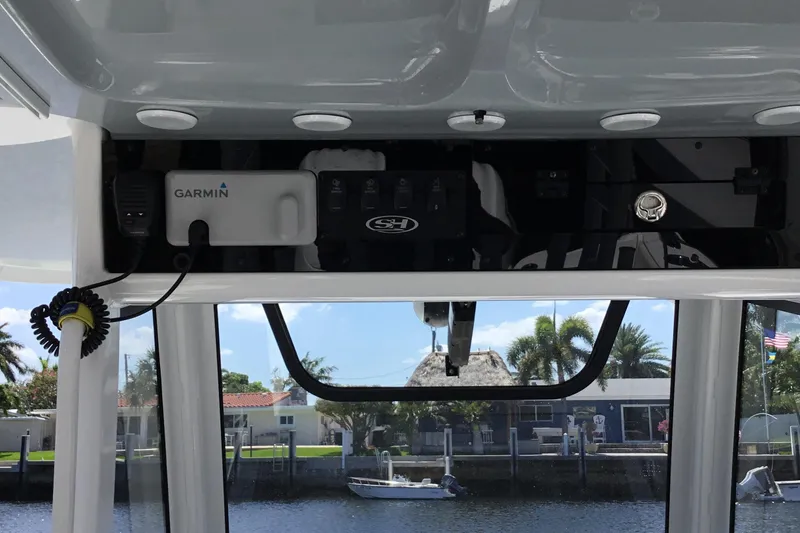 Slide: The Image of 2024 Sea Hunt Gamefish 28 Coffin Box boat dashboard with Garmin equipment, dockside view. - 37