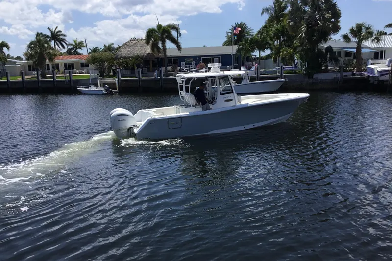 Slide: The Image of 2024 Sea Hunt Gamefish 28 Coffin Box boat cruising on a sunny waterfront. - 4