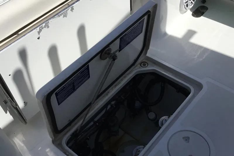 Slide: The Image of 2024 Sea Hunt Gamefish 28 Coffin Box storage compartment, open lid revealing interior components. - 46
