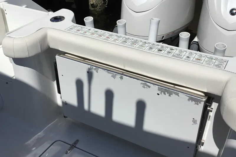 Slide: The Image of 2024 Sea Hunt Gamefish 28 Coffin Box interior with rod holders and cushioned seating. - 50