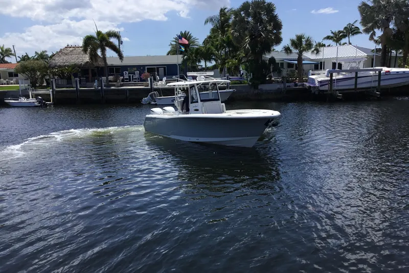 Slide: The Image of 2024 Sea Hunt Gamefish 28 Coffin Box boat cruising on a sunny waterfront. - 6