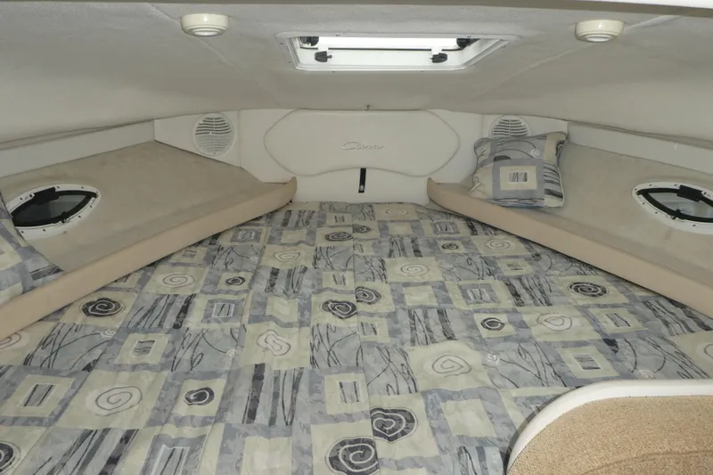 Slide: The Image of Interior cabin of 2002 Bayliner 2855 Ciera with patterned bedding and portholes. - 10