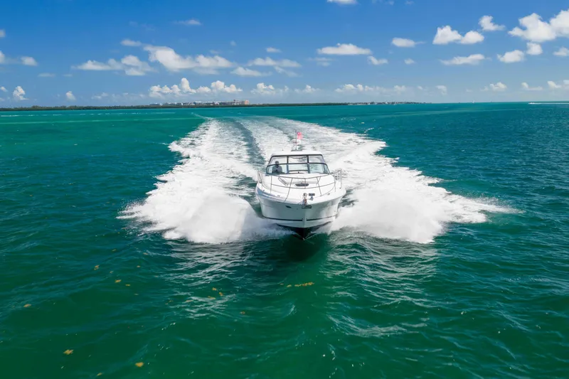 Slide: The Image of 2009 Sea Ray 40 Sundancer cruising on turquoise ocean under clear blue sky. - 10