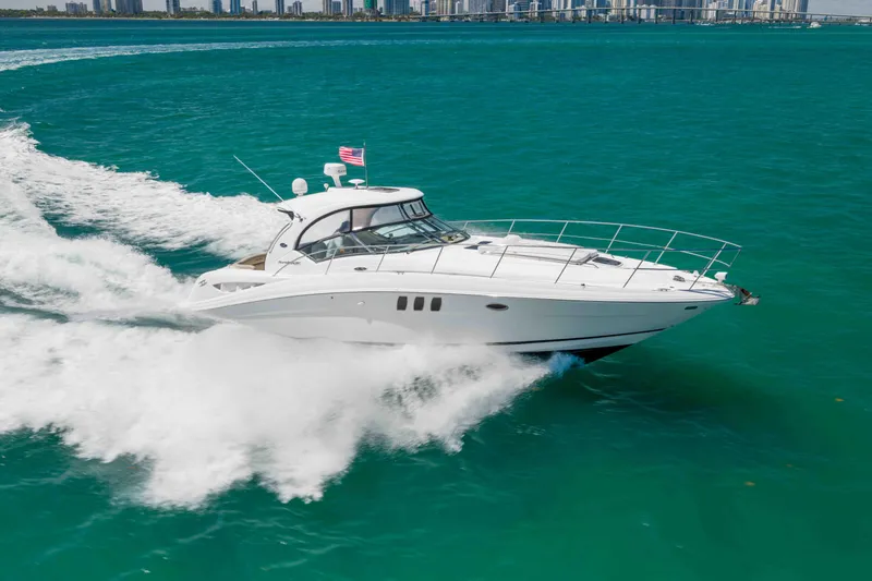 Slide: The Image of 2009 Sea Ray 40 Sundancer cruising on turquoise waters near city skyline. - 11