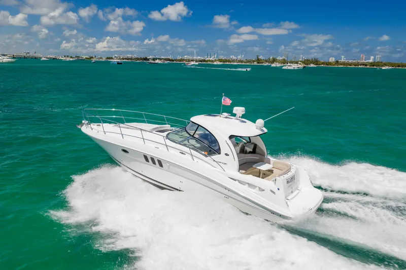 Slide: The Image of 2009 Sea Ray 40 Sundancer cruising on turquoise waters under a clear blue sky. - 12