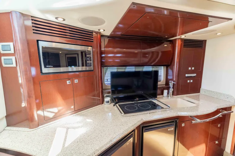 Slide: The Image of Luxurious 2009 Sea Ray 40 Sundancer yacht kitchen with modern appliances and sleek wood cabinetry. - 26