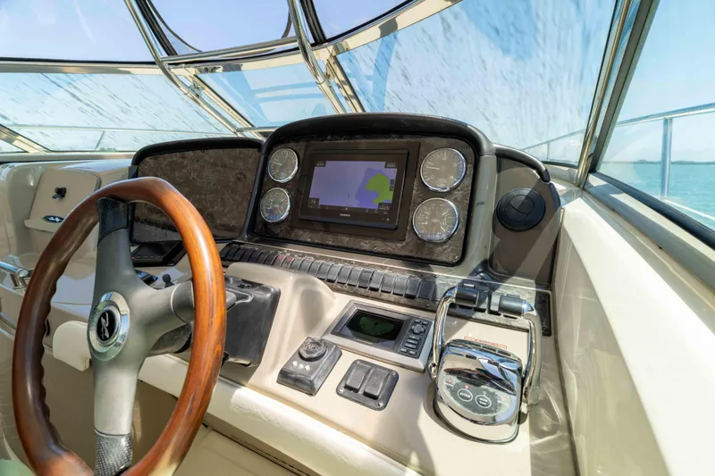 Slide: The Image of 2009 Sea Ray 40 Sundancer helm with navigation controls and wooden steering wheel. - 33