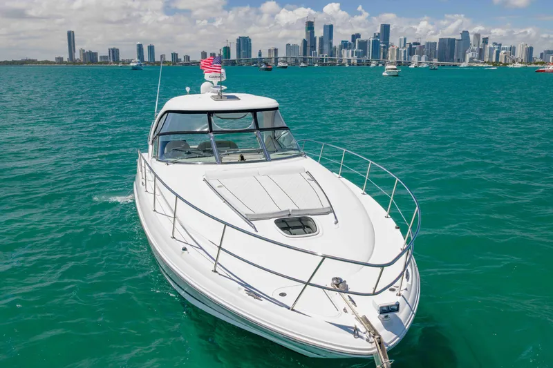 Slide: The Image of 2009 Sea Ray 40 Sundancer yacht cruising in turquoise waters with city skyline backdrop. - 9
