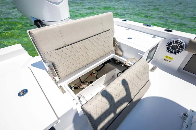 Slide: The Image of Manufacturer Provided Image: 2025 Sportsman Masters 247 Bay Boat with open storage compartment, beige seating, and ocean backdrop. - 19