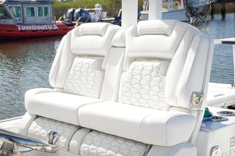 Slide: The Image of Luxurious white seating on 2026 Tidewater 3100 Carolina Bay boat, docked near water. - 10