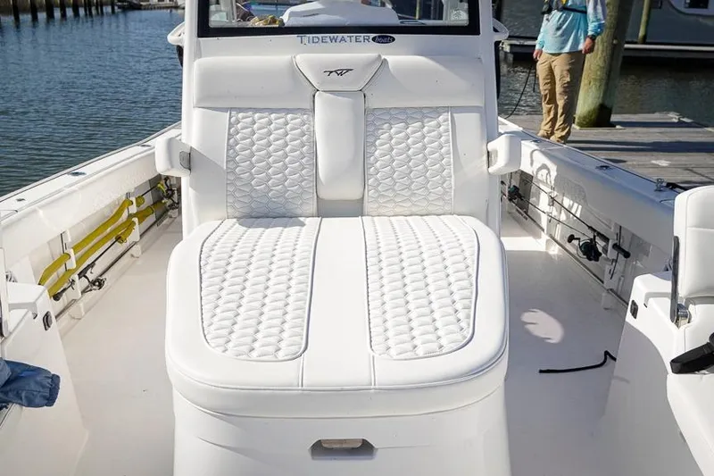 Slide: The Image of 2026 Tidewater 3100 Carolina Bay boat with luxurious white seating at a dock. - 26