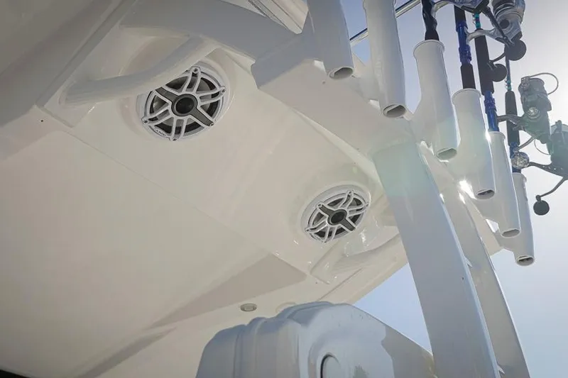 Slide: The Image of 2026 Tidewater 3100 Carolina Bay boat speakers and rod holders under bright sunlight. - 27
