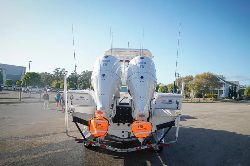 Slide: The Image of 2026 Tidewater 3100 Carolina Bay boat with dual outboard engines in a parking lot. - 38