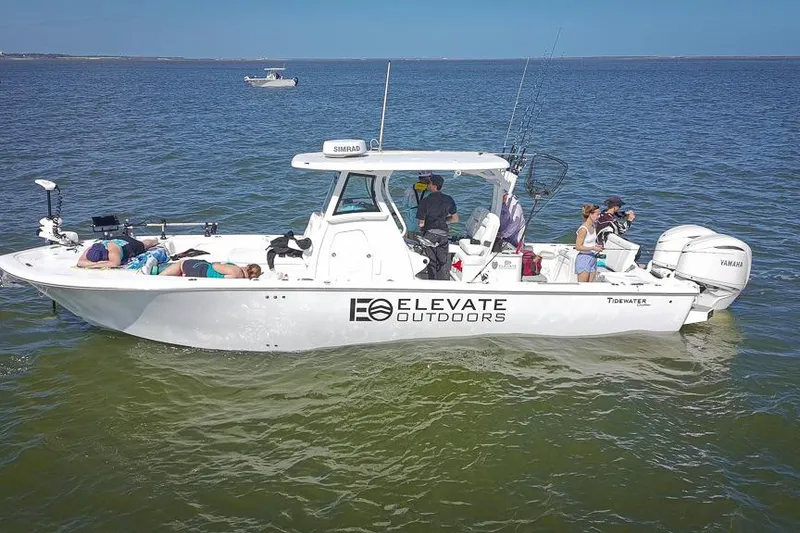 Slide: The Image of 2026 Tidewater 3100 Carolina Bay boat on water with people enjoying leisure activities. - 44