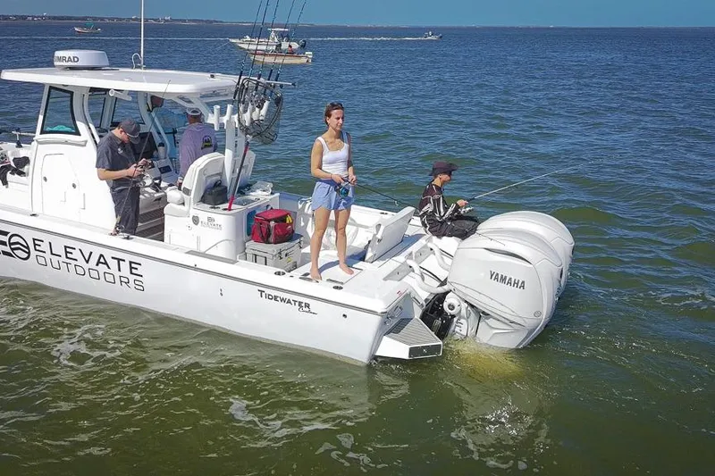 Slide: The Image of 2026 Tidewater 3100 Carolina Bay boat with people fishing on calm waters. - 45