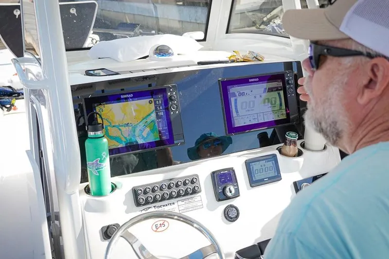 Slide: The Image of Man operating 2026 Tidewater 3100 Carolina Bay boat with navigation screens. - 9