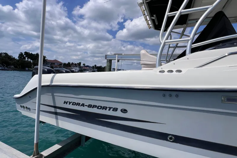 Slide: The Image of 2005 Hydra-Sports Vector 3300 VX boat docked on clear blue water under a cloudy sky. - 12
