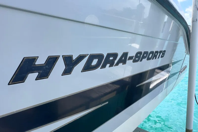 Slide: The Image of 2005 Hydra-Sports Vector 3300 VX boat side view with logo, docked on clear water. - 17