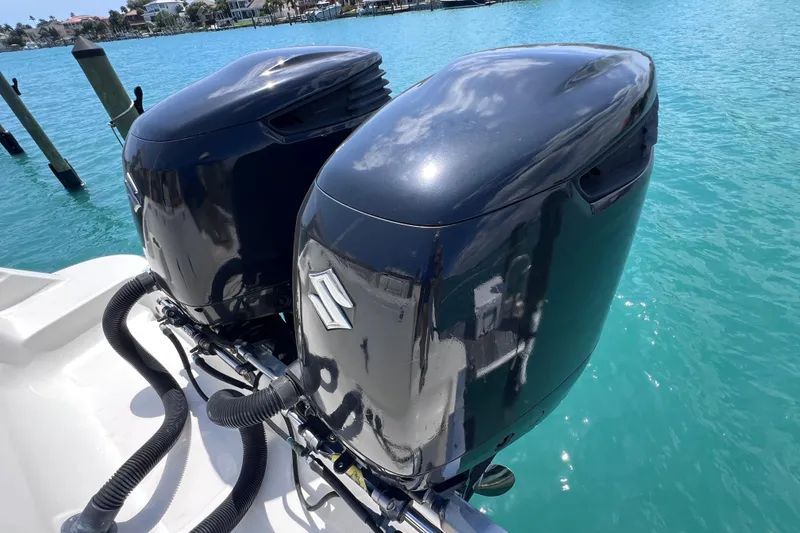 Slide: The Image of Twin outboard motors on a 2005 Hydra-Sports Vector 3300 VX, docked in clear blue water. - 26