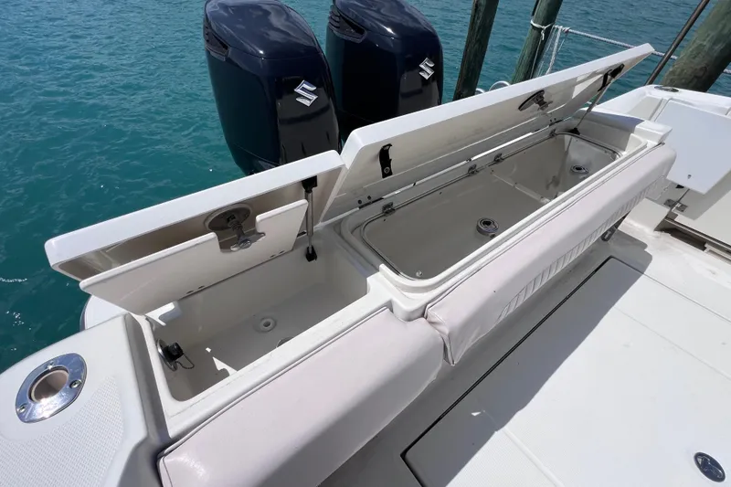 Slide: The Image of 2005 Hydra-Sports Vector 3300 VX boat with open storage compartments and dual outboard motors. - 28