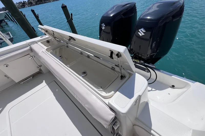 Slide: The Image of 2005 Hydra-Sports Vector 3300 VX boat with open storage compartment and dual Suzuki outboard motors. - 29