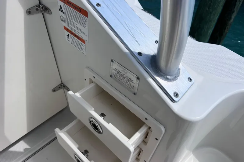 Slide: The Image of 2005 Hydra-Sports Vector 3300 VX boat interior with open storage drawers and warning labels. - 73