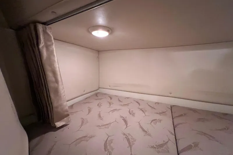 Slide: The Image of 2005 Hydra-Sports Vector 3300 VX cabin interior with patterned bedding and overhead light. - 88