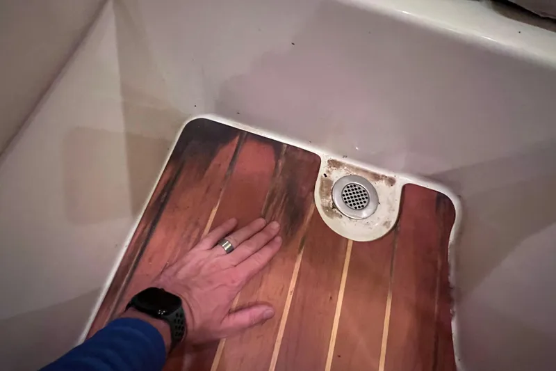 Slide: The Image of Hand touching wooden floor near drain in 2005 Hydra-Sports Vector 3300 VX boat. - 89