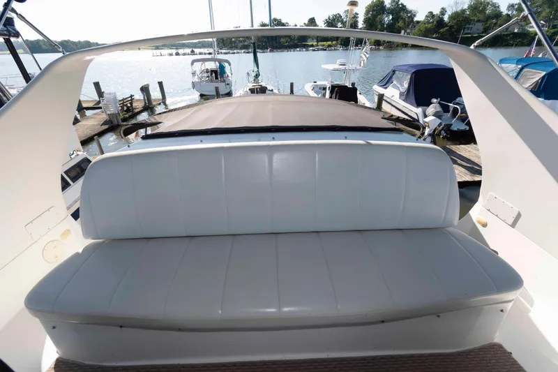 Slide: The Image of 2003 Carver 350 Mariner boat interior with white seating, docked at a marina. - 10