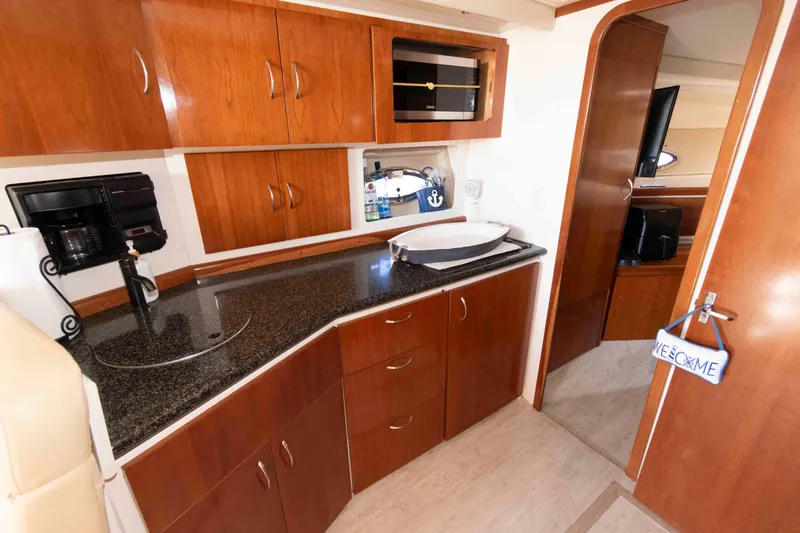 Slide: The Image of 2003 Carver 350 Mariner kitchen with wood cabinets, granite countertop, and modern appliances. - 17