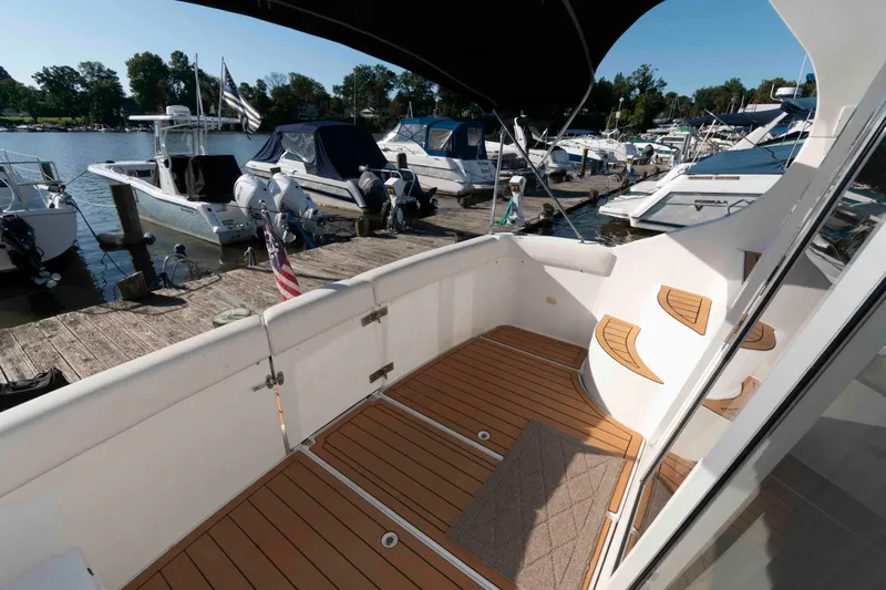 Slide: The Image of 2003 Carver 350 Mariner yacht docked at marina, featuring spacious deck and elegant design. - 3