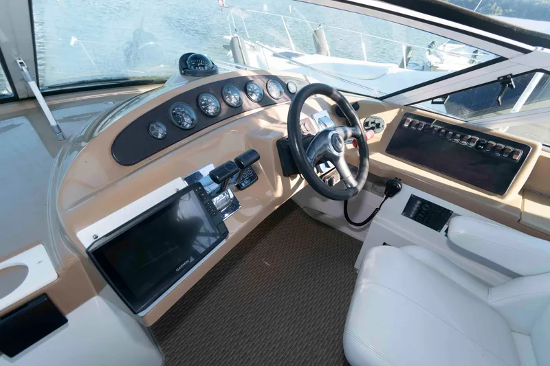 Slide: The Image of 2003 Carver 350 Mariner helm with steering wheel, gauges, and navigation equipment. - 6