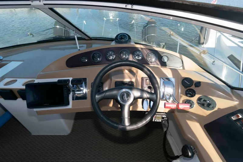 Slide: The Image of 2003 Carver 350 Mariner helm with steering wheel, gauges, and navigation equipment. - 7