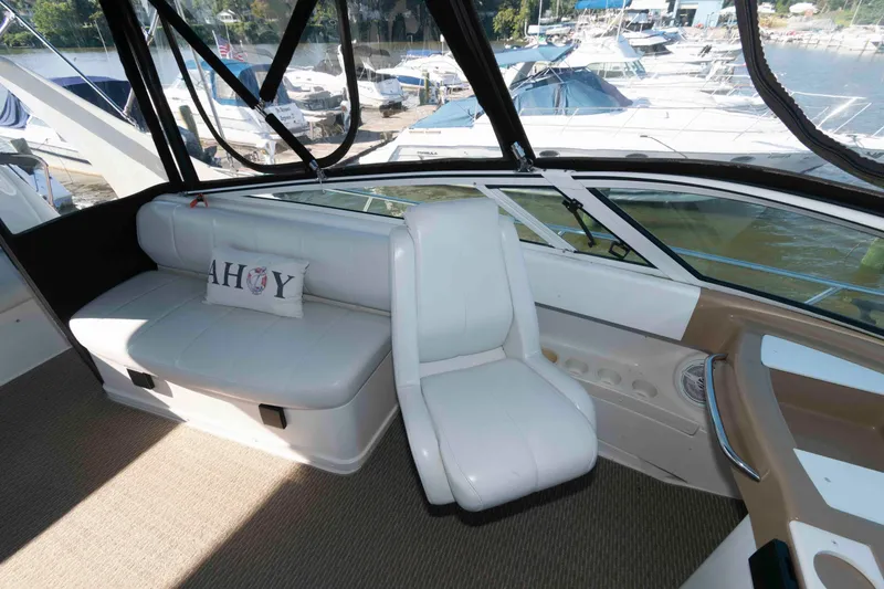 Slide: The Image of 2003 Carver 350 Mariner interior with white seating and "Ahoy" pillow, docked at marina. - 8