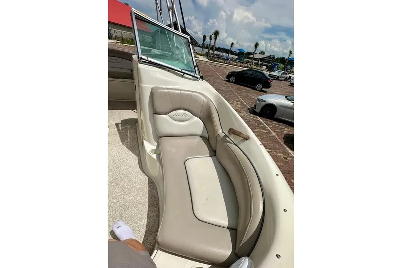 Slide: The Image of 2004 Sea Ray 200 Sundeck boat interior with beige seating and windshield. - 16