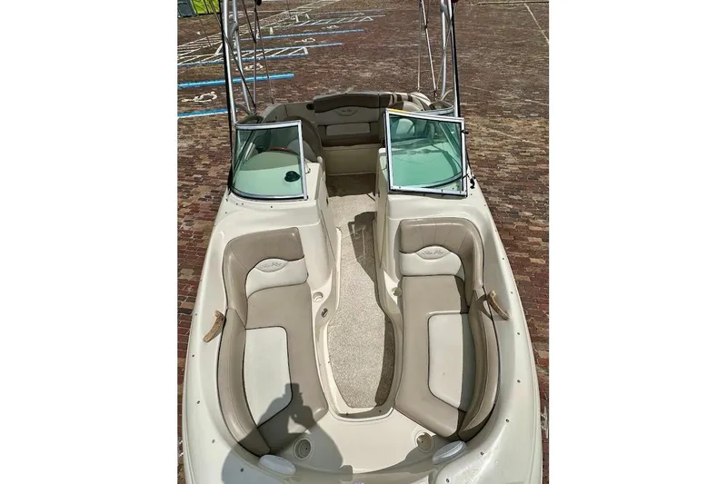 Slide: The Image of 2004 Sea Ray 200 Sundeck boat with beige seating and open deck layout. - 17