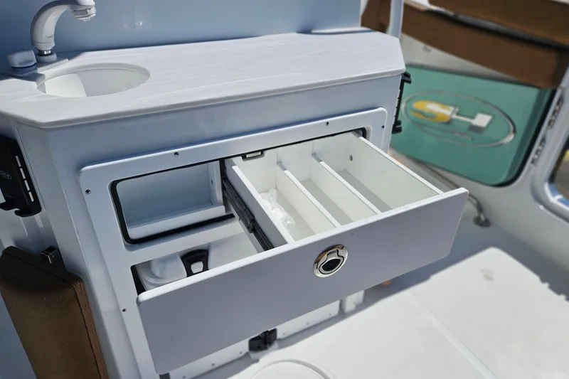 Slide: The Image of Interior view of 2026 Sea Hunt Ultra 255 SE boat with open storage drawer. - 13