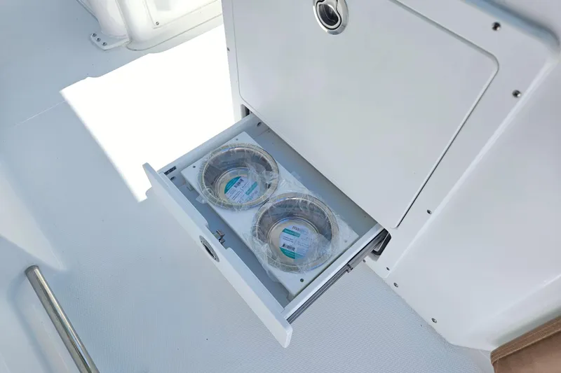 Slide: The Image of 2026 Sea Hunt Ultra 255 SE boat with open storage drawer containing packaged items. - 14