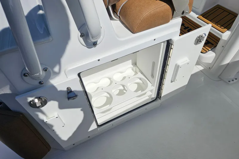 Slide: The Image of 2026 Sea Hunt Ultra 255 SE boat interior with open storage compartment and cup holders. - 16