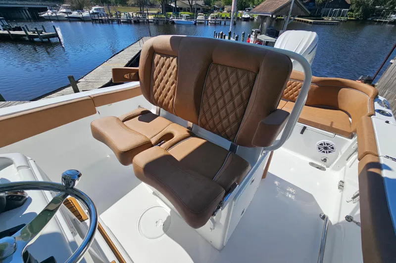 Slide: The Image of 2026 Sea Hunt Ultra 255 SE boat interior with luxurious brown seating by the water. - 18