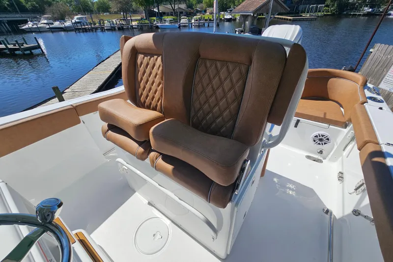Slide: The Image of Luxurious seating on 2026 Sea Hunt Ultra 255 SE boat, docked by a serene waterfront. - 19