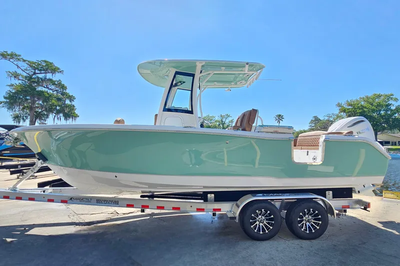 Slide: The Image of 2026 Sea Hunt Ultra 255 SE boat on trailer, parked outdoors under clear blue sky. - 2