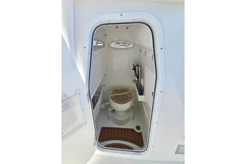 Slide: The Image of 2026 Sea Hunt Ultra 255 SE boat interior with compact marine toilet. - 22